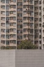 A close-up view of a densely packed residential building in Hong Kong, illustrating urban living