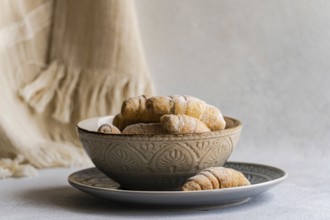 Homemade pastries in a decorative ceramic bowl on a plate. The setup exudes a rustic charm,
