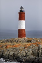 Lighthouse on rocky terrain under a cloudy sky, The lighthouse in the Beagle Channel near Ushuaia