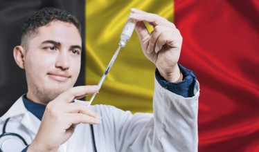 Doctor holding syringe on Belgium flag background. Medical professional holding syringe with
