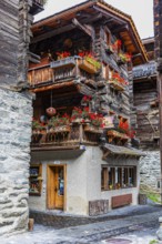 Old house decorated with flowers in the historic village centre, Grimentz, Val d'Anniviers, Valais