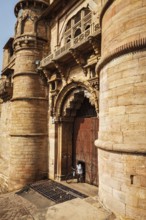 GWALIOR, INDIA, APRIL 11, 2011: Man with bicycle coming through door in huge gates of Gwalior Fort,