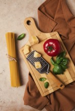 Raw pasta with ingredients on a beige background, top view, rustic style, selective focus, no