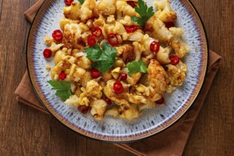 Spicy fried cauliflower served on a wooden countertop