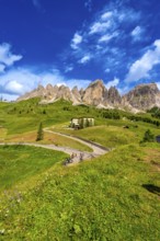 Bikers taking a break at gardena pass admiring the stunning view of the dolomites on a sunny summer