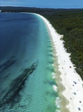 Aerial view of a pristine beach with vibrant turquoise waters and white sand in Jervis Bay,