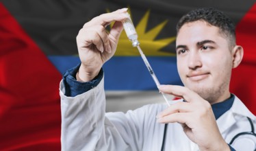 Doctor holding syringe on Antigua and Barbuda flag background. Medical professional holding syringe