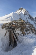 A rustic stone hut surrounded by snow against a majestic alpine backdrop. Ideal for ski touring