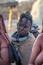 Himba girl, between Himba woman, portrait, in the morning, traditional Himba village, Kaokoveld,