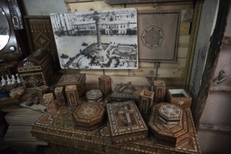 Damascus, Syria. December 10th 2025. A display of inlaid wooden mosaic boxes and an old black and
