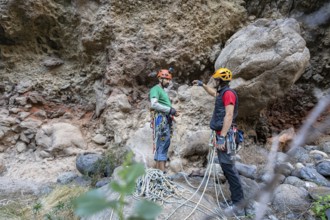 Two climbers prepare for a traditional climbing adventure in a rugged natural landscape, surrounded