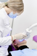 A dental professional in a clinic performing a specialized oral care procedure using modern