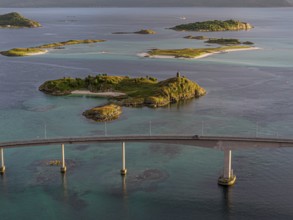 Sommaroy Bridge connecting Kvaloya Island to Sommaroy Island, warm light at sunset, aerial view,