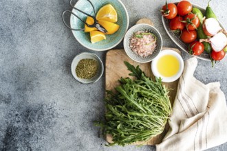 Fresh and healthy lunch setup with ingredients including rocket, chopped oregano, cherry tomatoes,