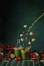 A dynamic display of green juice with spinach, strawberries, cherries, and grapes splashing in