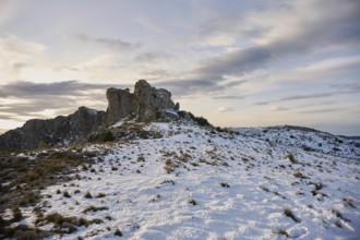 Stunning panoramic view of Montcabrer, Spain, showcasing a snow-covered mountain landscape at dusk,