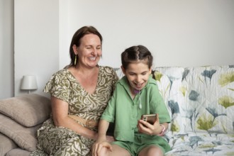 A joyful scene of a mother and her disabled daughter, who has a tracheostomy, sitting inside and