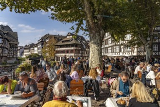 Busy cafe on Place Benjamin Zix and the Maison des Tanneurs timber-frame house in Petite France,