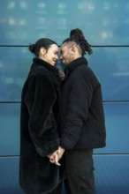 A multiethnic couple holds hands and shares a tender moment. This image symbolizes love,