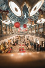 View of a decorated shopping mall with big golden bells and red balls on the ceiling, AppleMarket,