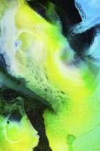 A dynamic abstract composition of swirling green, yellow, and blue inks. The vibrant textures and