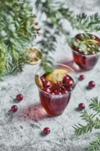 From above of glasses with cranberries with lemon next to Christmas decoration