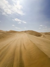Sweeping views of Ica's vast sand dunes stretch under a vibrant blue sky, showcasing the unique