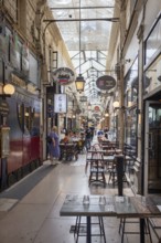 Passage with retro style, filled with food options and visitors, Paris