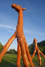Giraffes made of red painted tree trunks, wooden sculpture by Günter Schumann, Museum of the