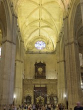 Gothic interior of a cathedral with high ceiling, stained glass window and organ, Seville,