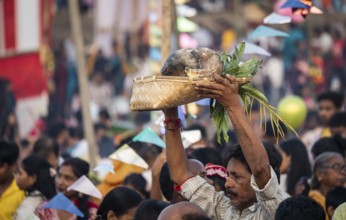 Hindu devotees gather on the banks of the Brahmaputra River to offer prayers to the Sun God on the