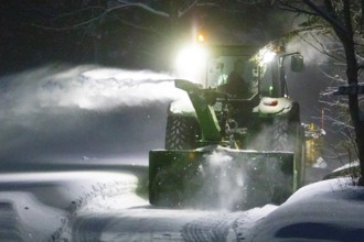 Heavy machinery clearing snow from a property entrance, Region of la Mauricie, Province of Quebec,