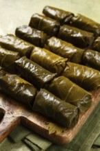 Dolma, minced meat with rice, in grape leaves, minced meat rolls, on a chopping board, top view, no