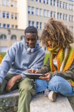 Millennial diverse student friends studying for an exam using digital tablet before going into