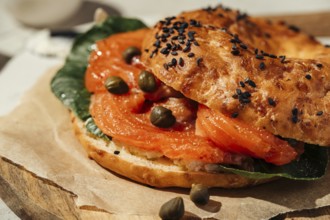 Close-up of a tasty bagel topped with smoked salmon, capers, and fresh greens. Perfect for