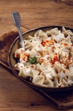 The dish features a generous serving of Turkish dumplings topped with velvety yogurt and a drizzle