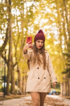 Portrait of a beautiful woman in autumn together in a forest in nature on a video call