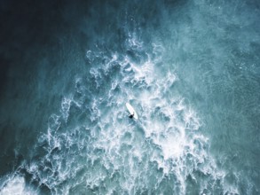 A stunning surf photo session in Portugal captures surfers navigating vibrant blue waves. The scene