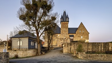 Evening view of a castle with courtyard, illuminated by warm light in front of sunset, Spangenberg
