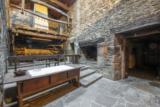 Rustic and traditional interior of a stone country house in Lugo, Spain, featuring a wooden balcony