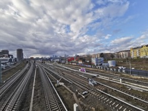 Panorma of urban rail infrastructure under a cloudy sky in summer with city in the background,