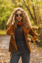 Vertical portrait of a beauty woman with sunglasses in a park during autumn