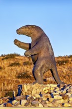 Large sloth statue on a rocky ground in a dry landscape with a clear sky, The statue of the giant
