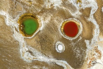 Top view, an aerial drone captures the striking colors of geological ponds within Salar de