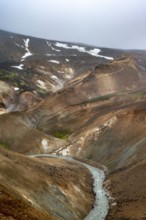 Steaming streams between colourful rhyolite mountains in the Hveradalir geothermal area,