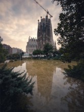 A tranquil scene in Barcelona featuring the iconic Sagrada Familia, its detailed spires reflected