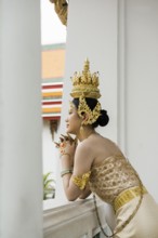 Thai traditionally and festively dressed young woman, Wat Pho, Bangkok, Thailand