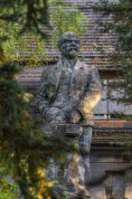 Statue of Vladimir Ilyich Lenin in front of the ruins of the Officers' House, officers' mess at the