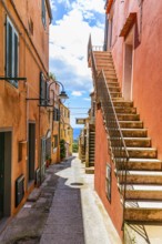 Houses with pastel-coloured façades and steep stone steps, Via Roma, Capoliveri, Elba Island,