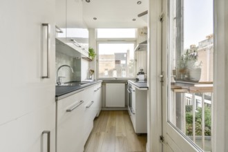 A contemporary kitchen featuring sleek cabinetry, natural light flooding in from large windows, and